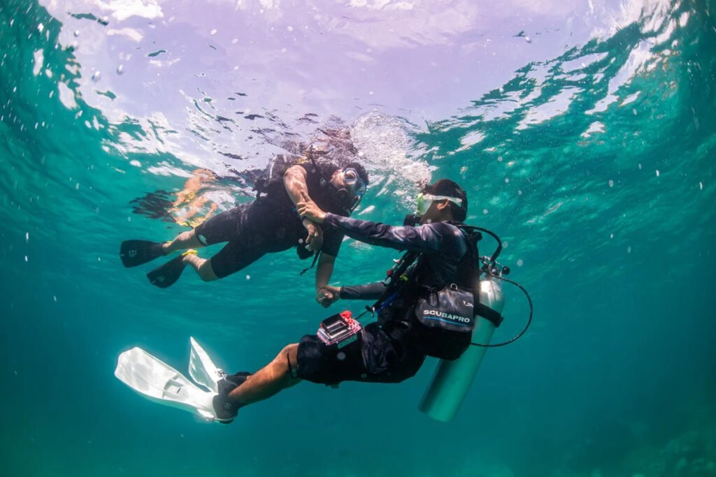 PADI instructor assisting beginner scuba diver in clear water in Phuket