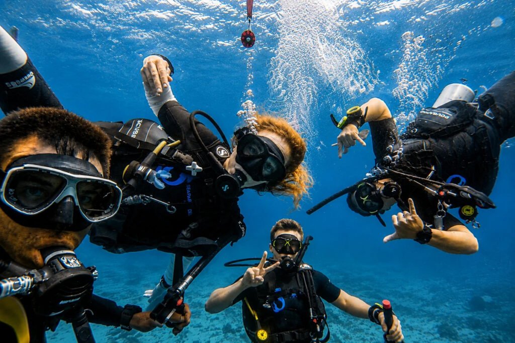 Scuba divers enjoying a fun underwater experience in Phuket with Seafarer Divers Phuket Description: A group of scuba divers enjoying a fun underwater moment in clear tropical water, ideal for promoting Phuket scuba diving experiences, beginner-friendly dive trips, and premium underwater adventures with Seafarer Divers Phuket